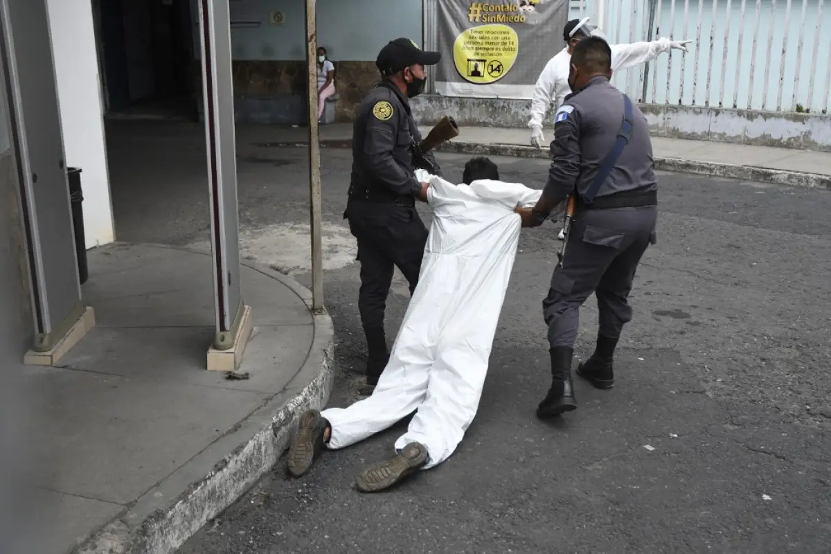 Penitentiary system guards carry an inmate with symptoms related to the novel coronavirus at the COVID-19 unit of San Juan de Dios hospital in Guatemala City on July 13, 2020. (Photo by Johan ORDONEZ / AFP)