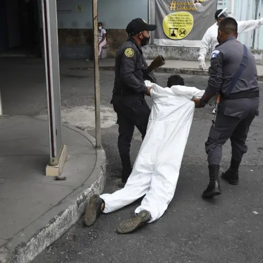 Penitentiary system guards carry an inmate with symptoms related to the novel coronavirus at the COVID-19 unit of San Juan de Dios hospital in Guatemala City on July 13, 2020. (Photo by Johan ORDONEZ / AFP)