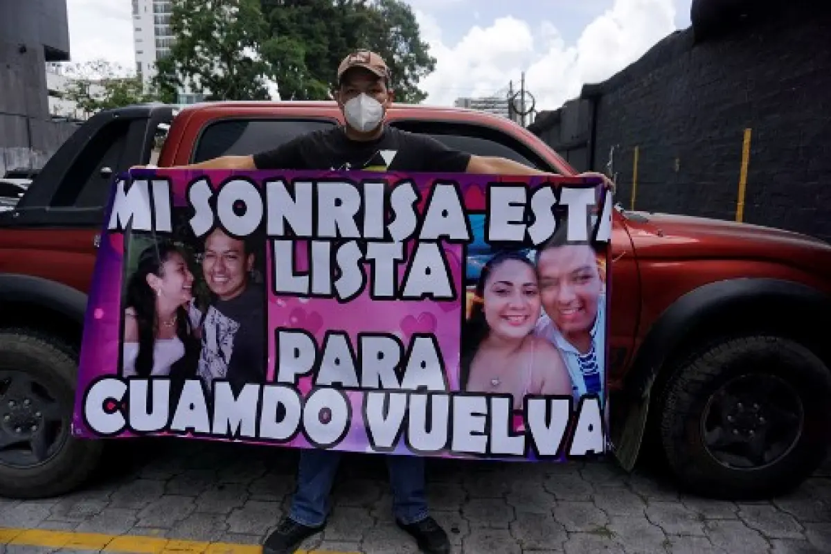 Guatemalan Miguel Angel Taque, 26, holds a banner that reads "My smile is ready for when you come back" made it to support his girlfriend Yoselin Solorzano who remains isolated on the fifth floor of a hotel after testing positive for the novel coronavirus