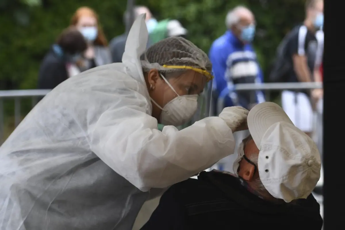 A medical staff collects a swab sample from a man at a test centre for the novel coronavirus (Covid-19) in Quiberon, western France, in Quiberon, western France on July 27, 2020. - France ordered nighttime curfews for beaches in the Brittany resort of Qui