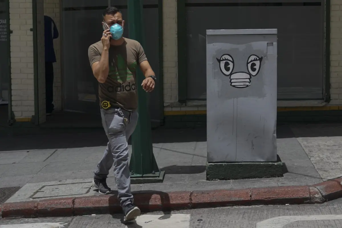 A man wearing a face mask walks in a street of Guatemala City on July 16, 2020 amid the COVID-19 coronavirus pandemic. (Photo by Johan ORDONEZ / AFP)