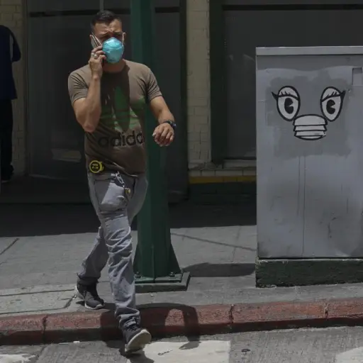 A man wearing a face mask walks in a street of Guatemala City on July 16, 2020 amid the COVID-19 coronavirus pandemic. (Photo by Johan ORDONEZ / AFP)