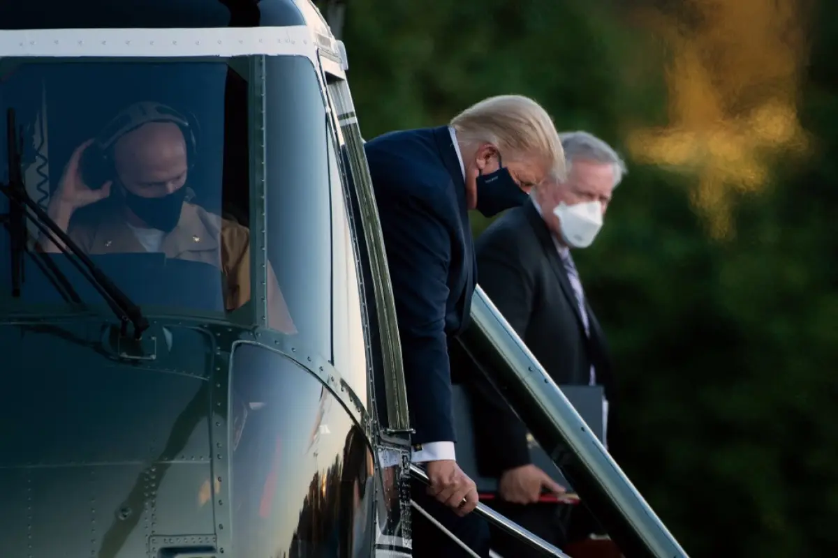 White House Chief of Staff Mark Meadows (R) watches as US President Donald Trump walks off Marine One while arriving at Walter Reed Medical Center in Bethesda, Maryland on October 2, 2020, after testing positive for covid-19. - President Donald Trump will