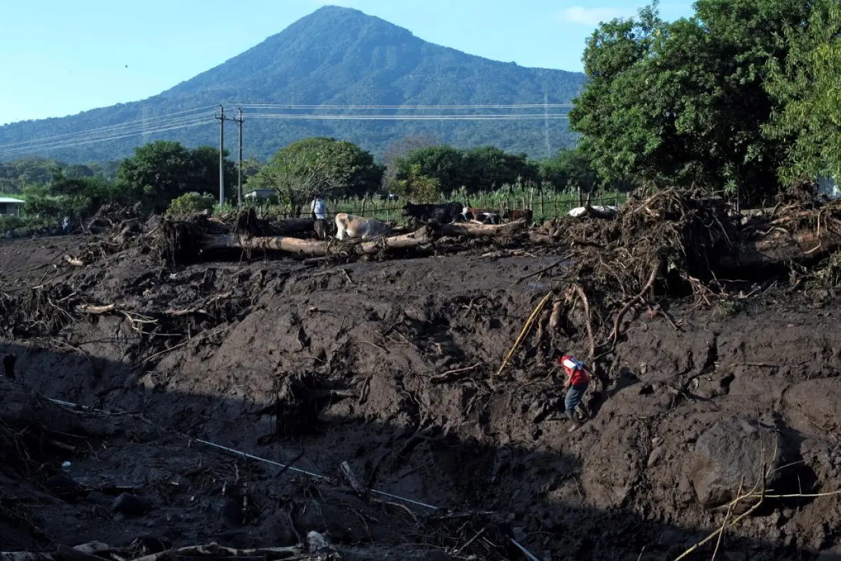 A resident descends the a riverbank left after a landslide near the San Salvador volcano in Nejapa, El Salvador on October 30, 2020. - A landslide caused by heavy rains left six people dead, 35 disappeared and some 50 homes buried in a rural community of 