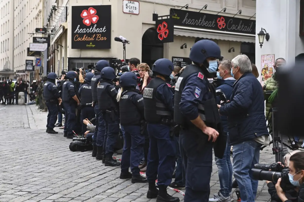 Journalists stand behind a cordon of policemen prior to a ceremony to pay homage to the victims of a shooting in Vienna on November 3, 2020, one day after the shooting at multiple locations across central Vienna. - A huge manhunt was under way after gunme