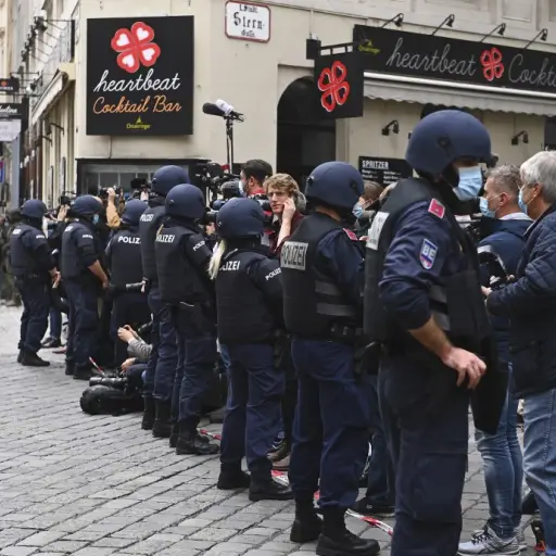Journalists stand behind a cordon of policemen prior to a ceremony to pay homage to the victims of a shooting in Vienna on November 3, 2020, one day after the shooting at multiple locations across central Vienna. - A huge manhunt was under way after gunme