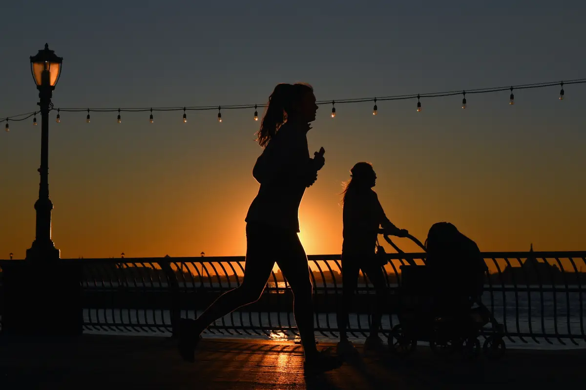 People exercise during sunset amid the Coronavirus pandemic on December 10, 2020 in New York City. - An expert committee convened by the US Food and Drug Administration on December 10, 2020, voted heavily in favor of recommending the Pfizer-BioNTech Covid