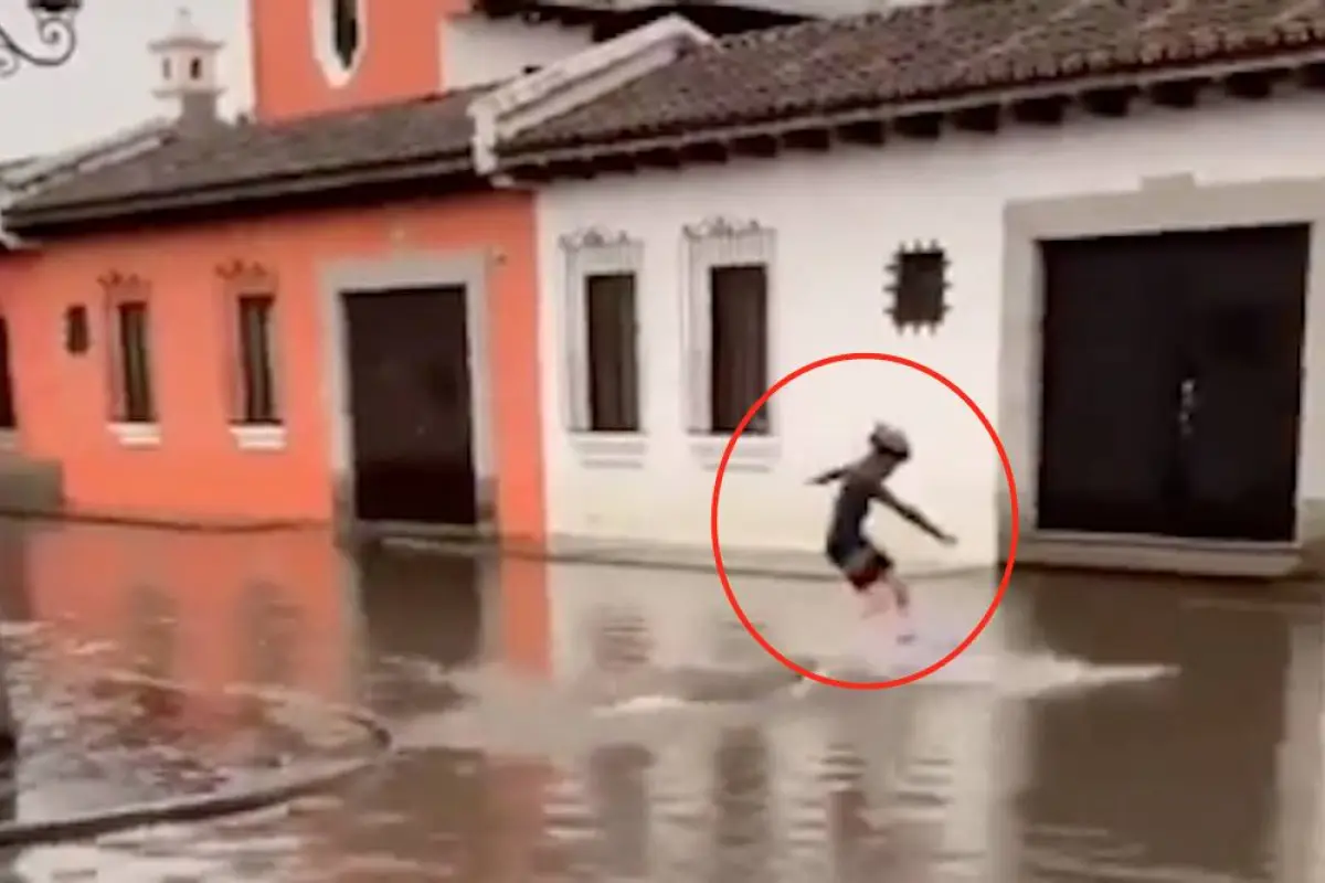 Joven aprovecha inundación en Antigua Guatemala para surfear, 