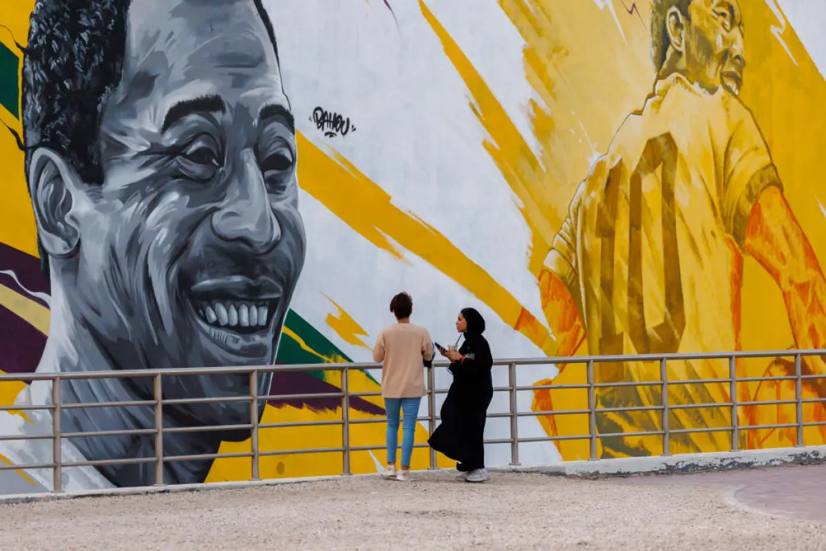 DOHA, QATAR - NOVEMBER 18: Fans observe a mural of football legend Pele ahead of the FIFA World Cup Qatar 2022 on November 18, 2022 in Doha, Qatar. (Photo by Buda Mendes/Getty Images)