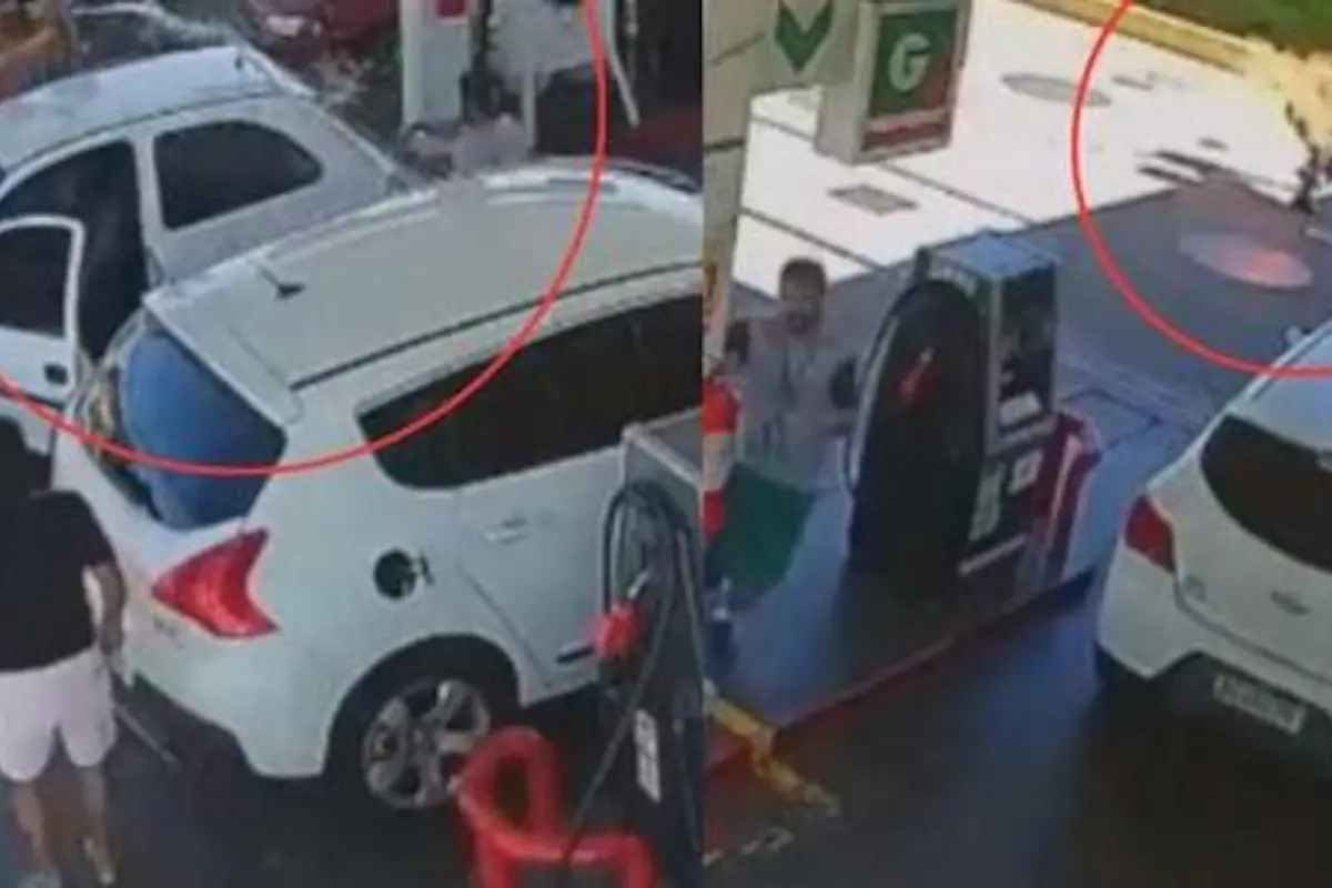 empleado de gasolinera echa combustible a cliente, 