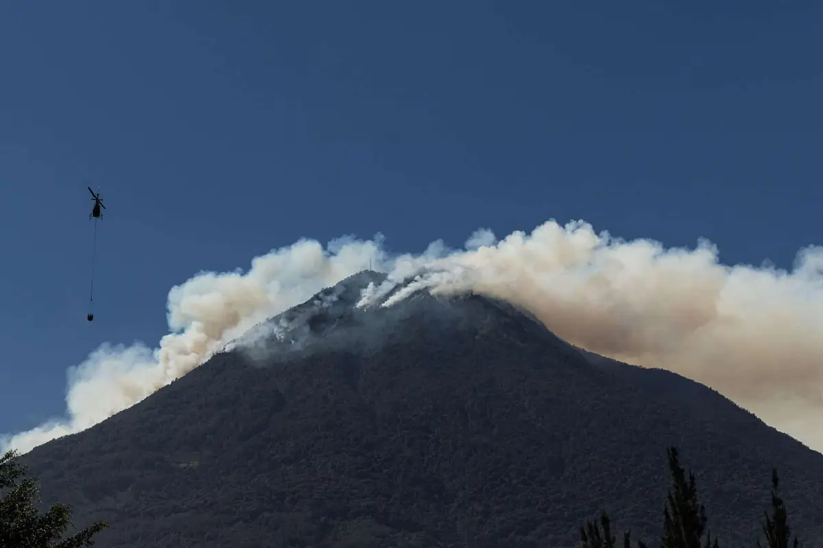 Un helicóptero trabaja en el control de un incendio forestal en el Volcán de Agua, cerca de Antigua Guatemala. Foto: EFE