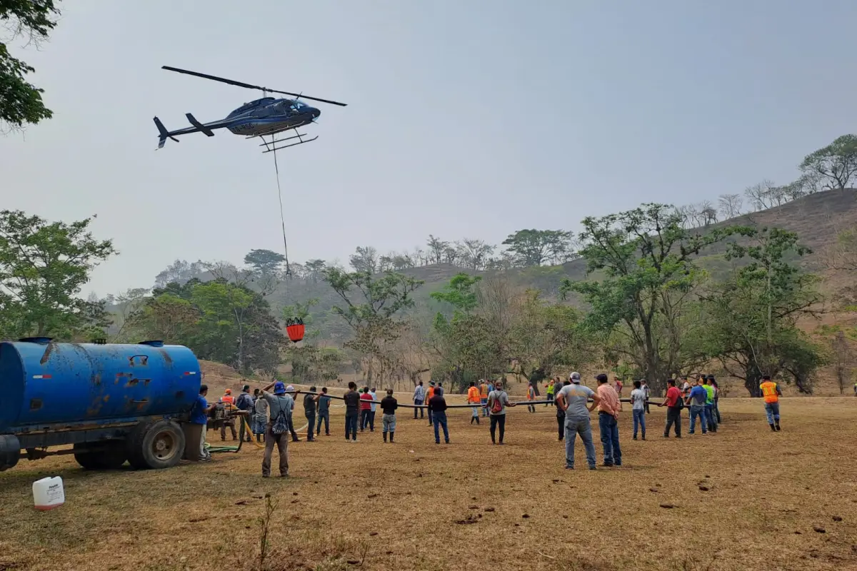 Autoridades y voluntarios trabajan para apagar las llamas que afectan el caserío Chisip, Santa María Cahabón, Alta Verapaz. Foto: Conred.