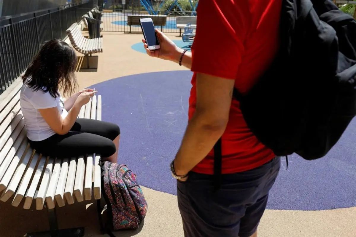 Fotografía de archivo en donde se ven jóvenes que usan sus teléfonos en un parque. EFE