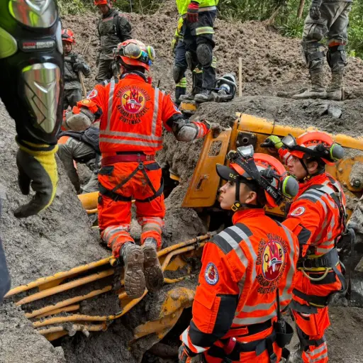 Los socorristas trabajan con herramientas para extraer el cuerpo de la tercera persona localizada debido a que se encuentra dentro de la cabina de una retroexcavadora. Foto: Bomberos Voluntarios