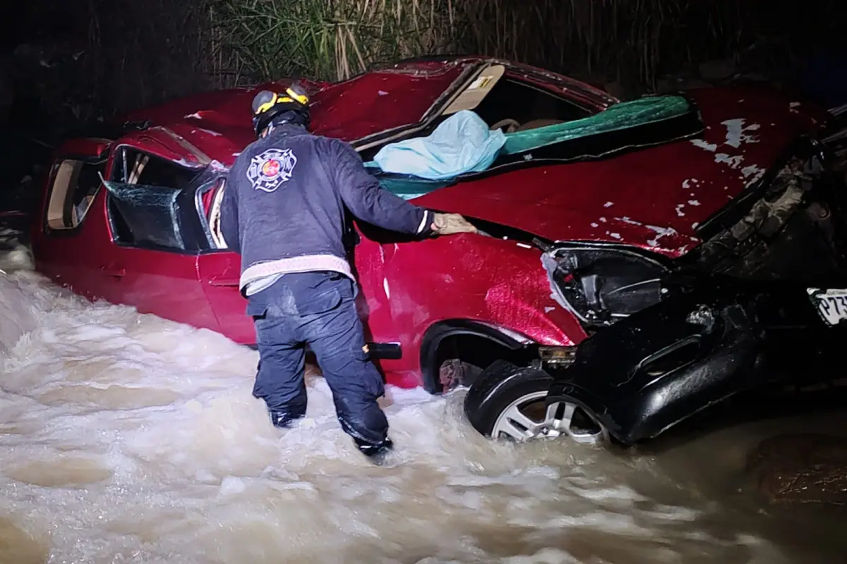 Los rescatistas se acercaron al carro que se accidentó para sacar a los ocho pasajeros, en medio de una fuerte corriente de agua.