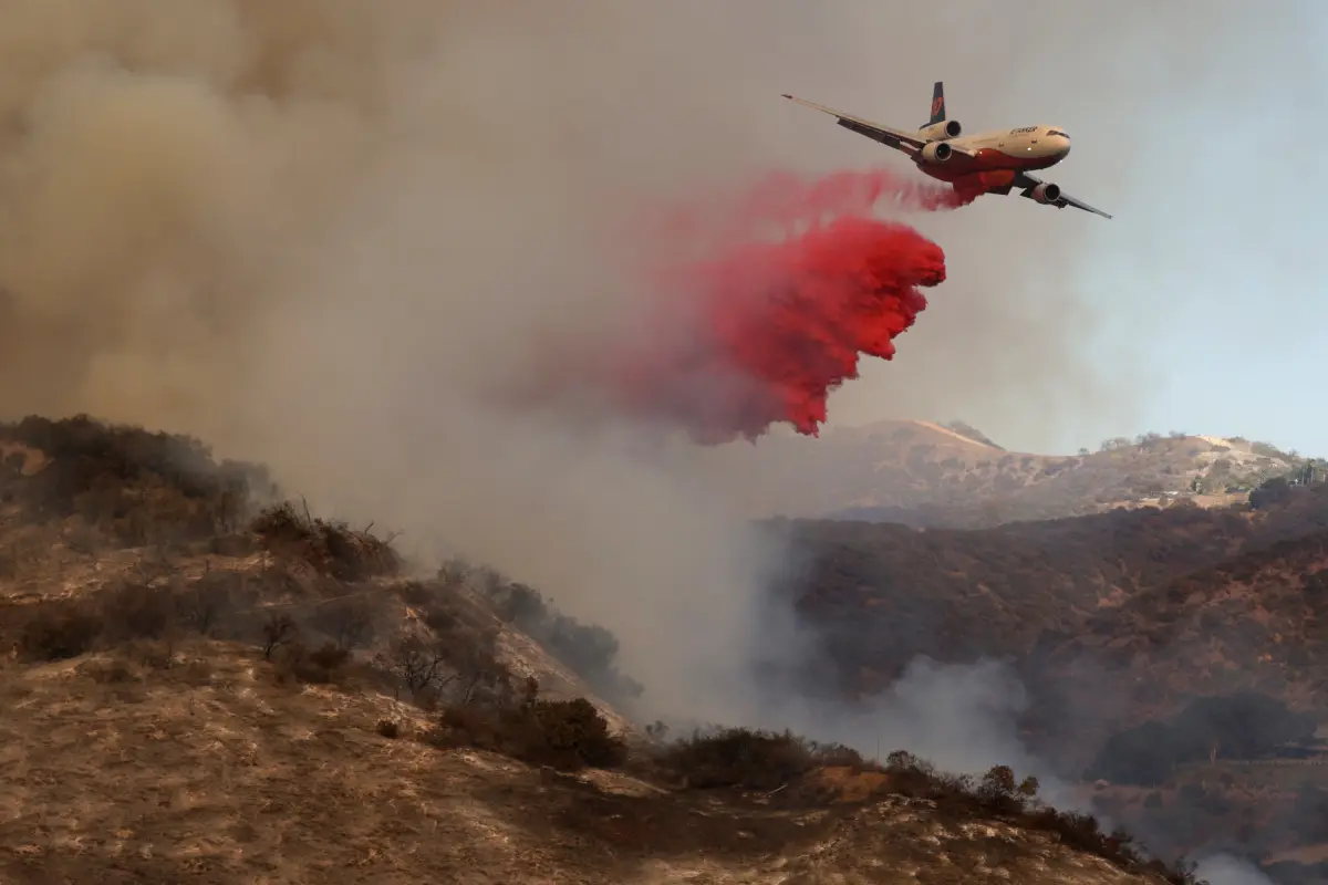 Un avión lanza retardante de fuego contra el incendio forestal de Palisades en Los Ángeles, California., Foto EFE