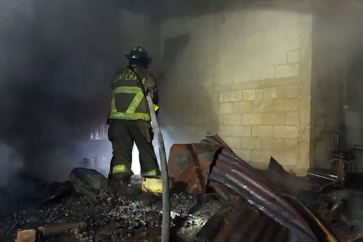 Bomberos trabajando en el inmueble incendiado en zona 3., Bomberos Voluntarios