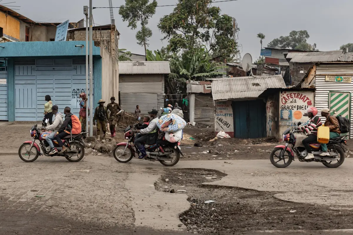 El fotógrafo de EFE, Michel Lunanga, captó a varias personas escapando con sus pertenencias, en medio de un ataque rebelde., EFE