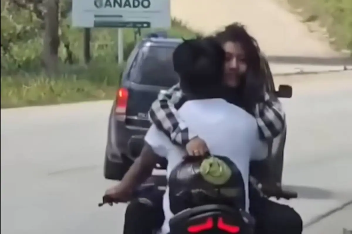 Exhiben a motorista que transportaba a pasajera en una peligrosa maniobra., Captura de pantalla video X.