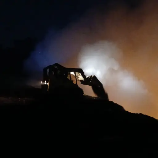 La retroexcavadora trabaja durante la noche en el vertedero de AMSA. ,Conred.