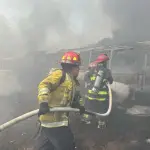 Los socorristas buscan controlar las llamas que consumen los buses. ,Bomberos Municipales Departamentales