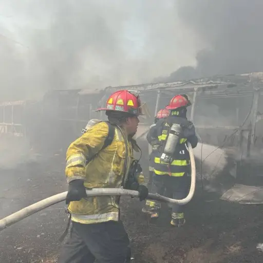 Los socorristas buscan controlar las llamas que consumen los buses. ,Bomberos Municipales Departamentales