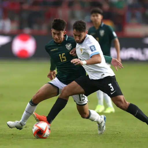 Gabriel Villamíl (i) de Bolivia disputa un balón con Sebastián Cáceres de Uruguay en un partido de las eliminatorias sudamericana