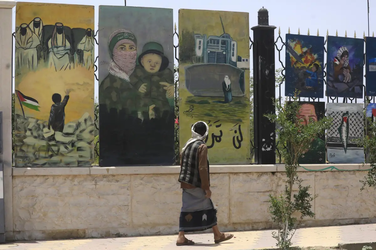 Una persona pasa junto a una valla adornada con obras de arte pro-palestinas en Saná, Yemen, 11 de mayo de 2025,  EFE/EPA/YAHYA ARHAB

