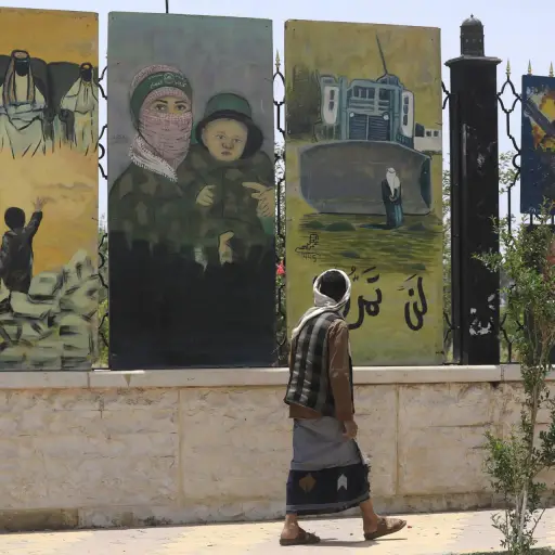 Una persona pasa junto a una valla adornada con obras de arte pro-palestinas en Saná, Yemen, 11 de mayo de 2025 , EFE/EPA/YAHYA ARHAB