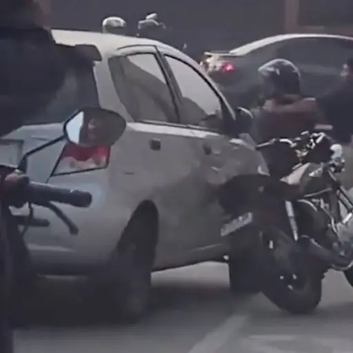 Automovilista y motorista se enfrentan a golpes. ,Captura de pantalla video X.