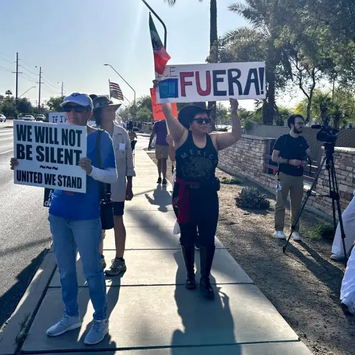 Personas sostienen carteles y banderas durante una manifestación este sábado, en Tucson (Estados Unidos) , EFE/ María León