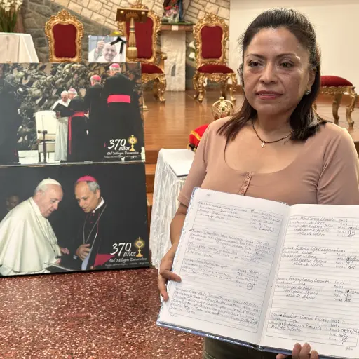Noemi Ñiquen, integrante de la parroquia Santa María Magdalena, sostiene unos cuadernos con testimonios de fe hechos por visitantes a la parroquia este viernes, en Eten, provincia de Chiclayo (Perú).  ,Foto EFE