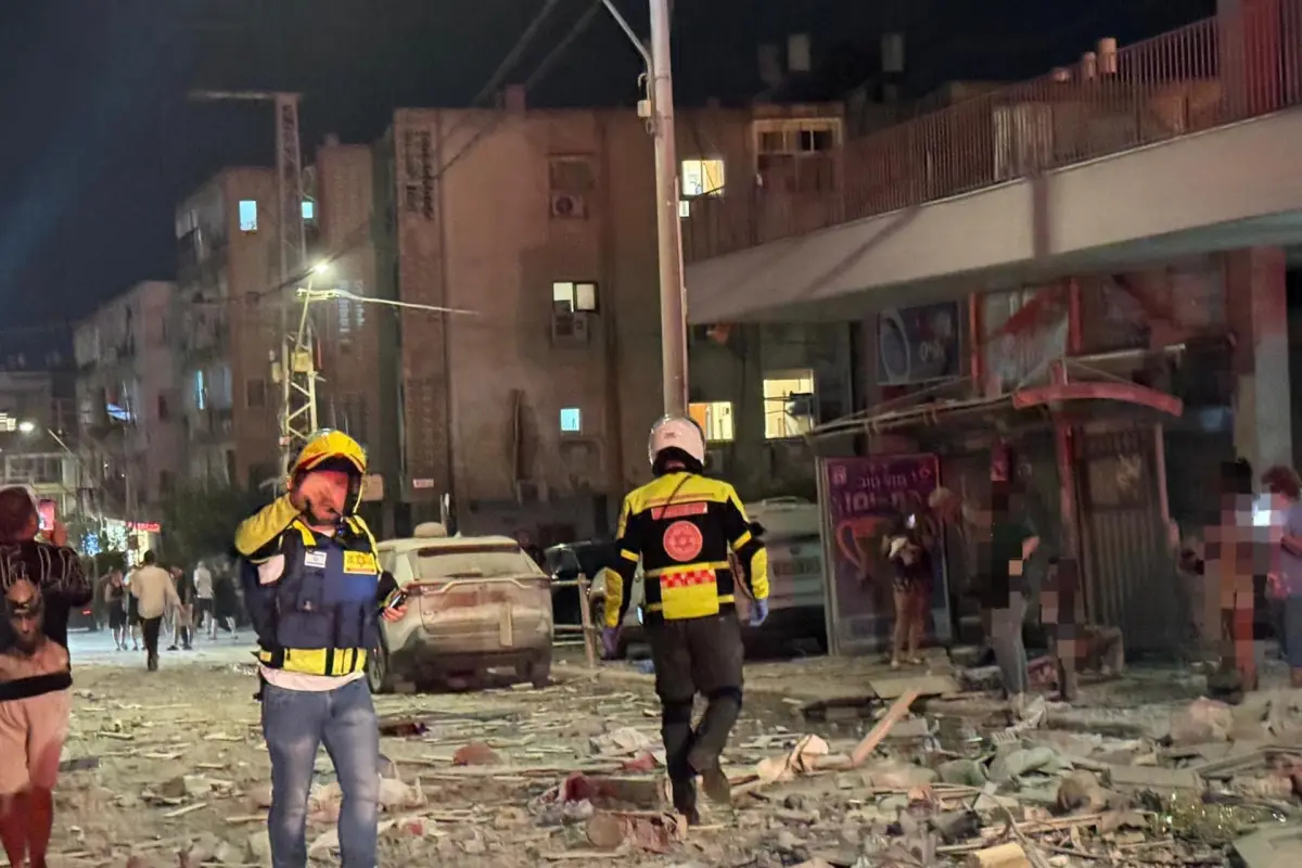 Integrantes de equipos de emergencia, bomberos y policía, trabajan en el área donde un proyectil iraní impactó provocando el derrumbe de un edificio en la madrugada de este domingo, en el Sur del Distrito Tel Aviv (Israel),  EFE/ Magen David Adom MÁXIMA CALIDAD DISPONIBLE
