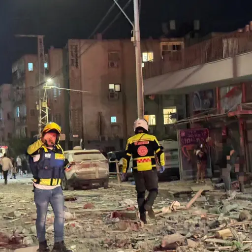 Integrantes de equipos de emergencia, bomberos y policía, trabajan en el área donde un proyectil iraní impactó provocando el derrumbe de un edificio en la madrugada de este domingo, en el Sur del Distrito Tel Aviv (Israel) , EFE/ Magen David Adom MÁXIMA CALIDAD DISPONIBLE