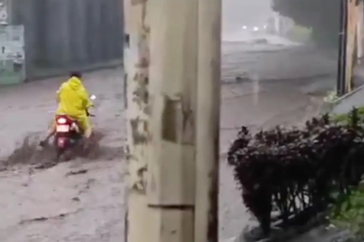 En las imágenes se ve como la mujer lucha por pasar con su moto,, pero es arrastrada por el agua., Redes sociales.