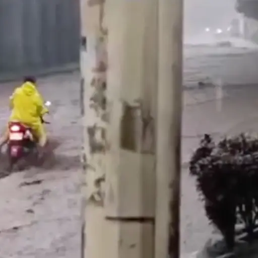 En las imágenes se ve como la mujer lucha por pasar con su moto,, pero es arrastrada por el agua. ,Redes sociales.