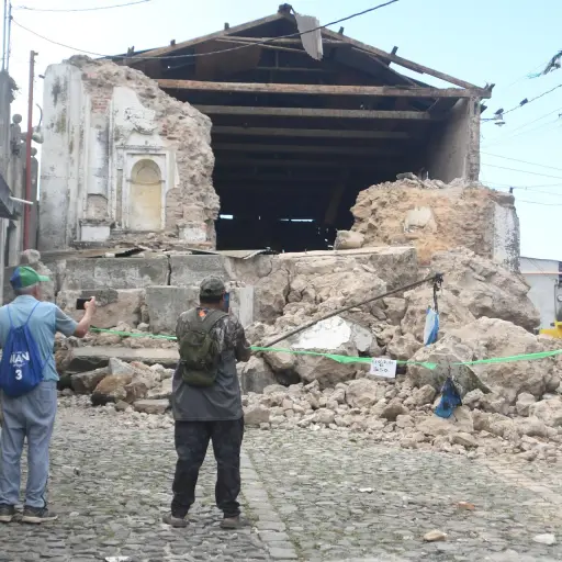 Personas observan este miércoles una edificación destruida por los temblores ocurridos el martes, en Santa María de Jesús. ,EFE
