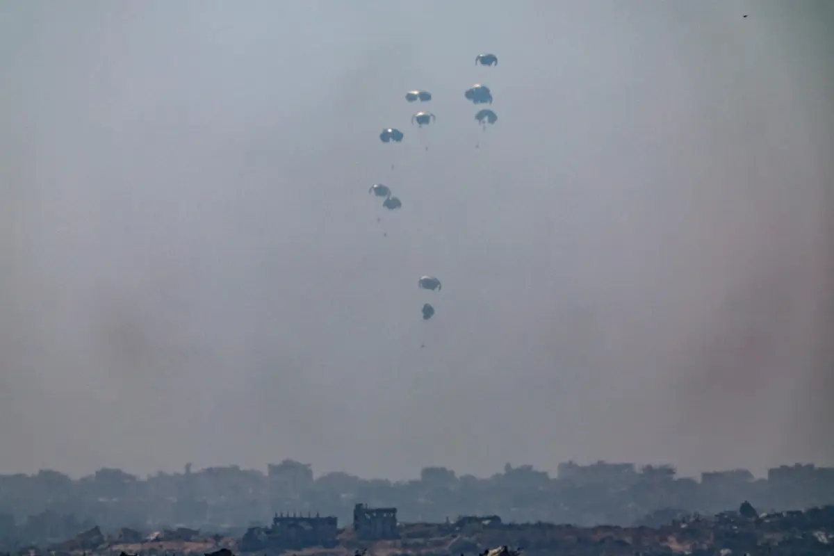 El Ejército jordano lanza ayuda humanitaria en paracaídas sobre la parte norte de la Franja de Gaza, según se ve desde Sderot, en el sur de Israel, este domingo 27 de julio de 2025, para aliviar la crisis humanitaria que ha provocado la muerte por desn,  EFE/EPA/ATEF SAFADI

