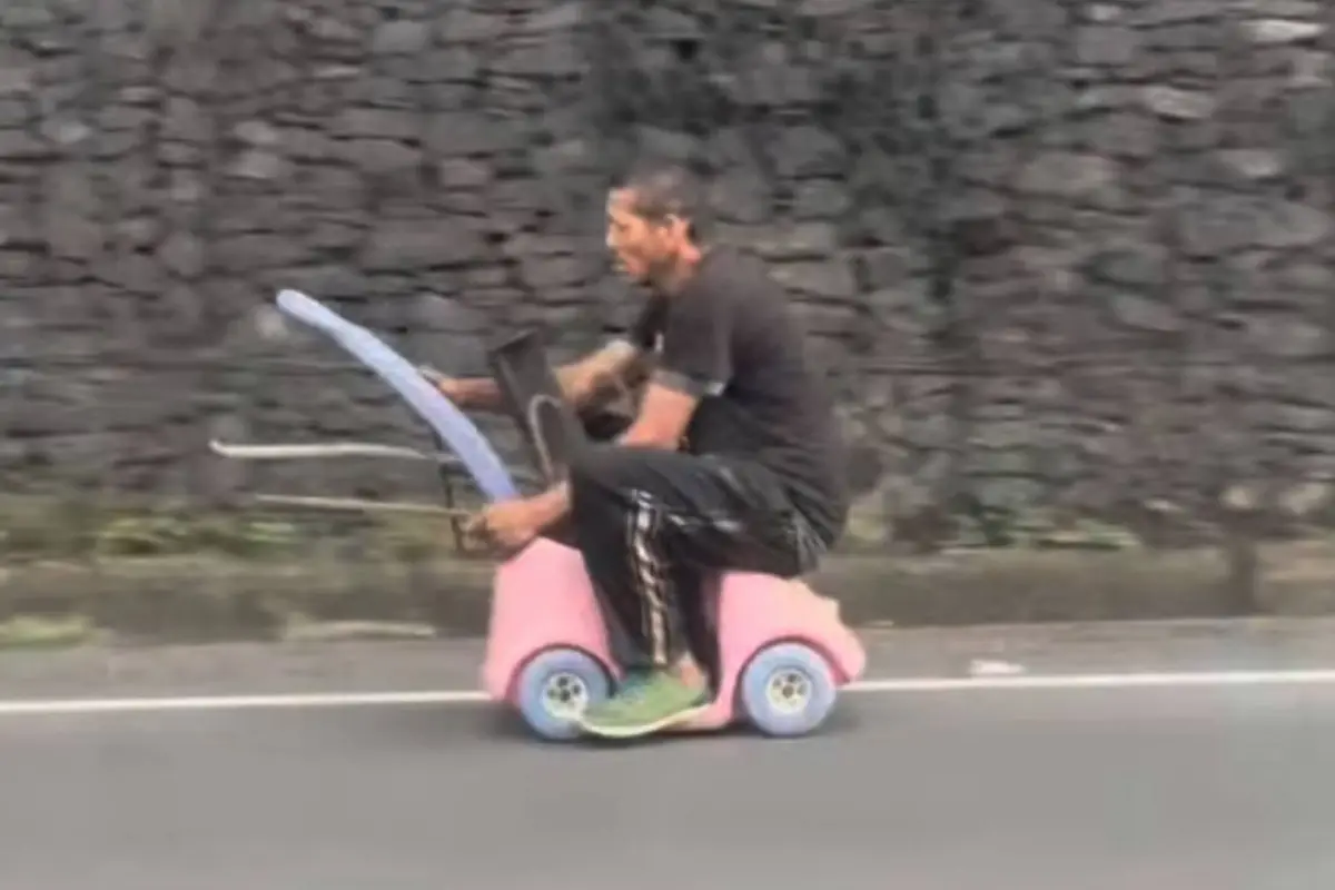 Hombre circula en carro de juguete., Captura de pantalla video X.