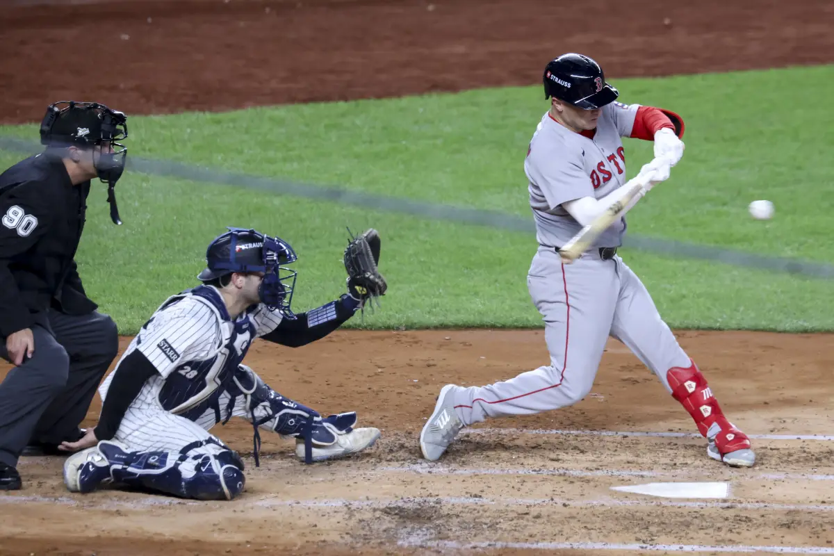 Alex Bregman (R) de los Medias Rojas golpea este juego la pelota durante el tercer juego de la Serie de Comodines de la Liga Americana de la MLB contra los Yanquis de New York