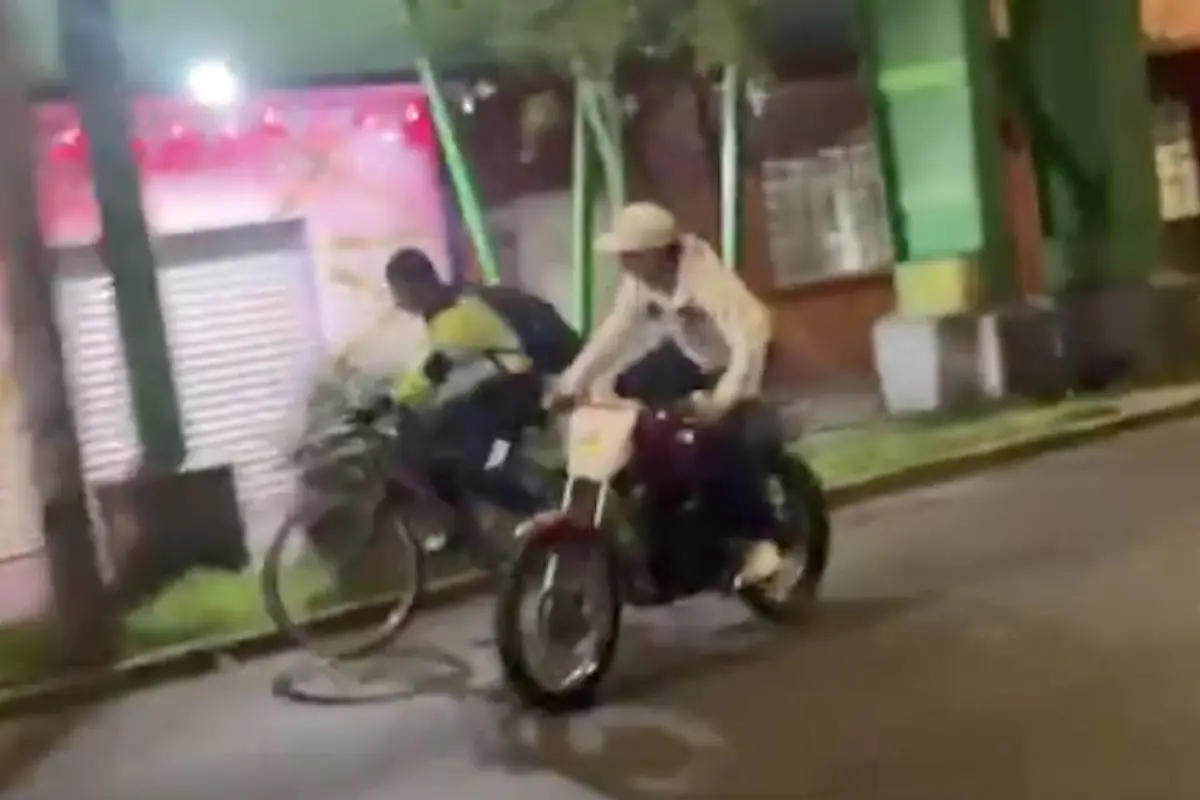 Motorista empuja a ciclista en carretera., Captura de pantalla video TikTok.