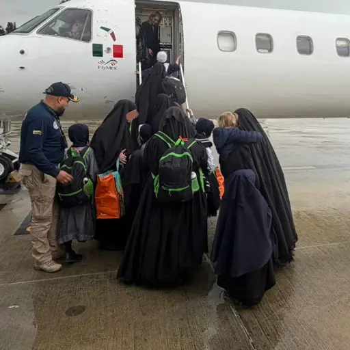Imagen cedida por la oficina de comunicaciones de Migración Colombia que muestra a integrantes de Lev Tahor subiendo a un avión luego de ser expulsados del país hacia EE. UU. ,EFE