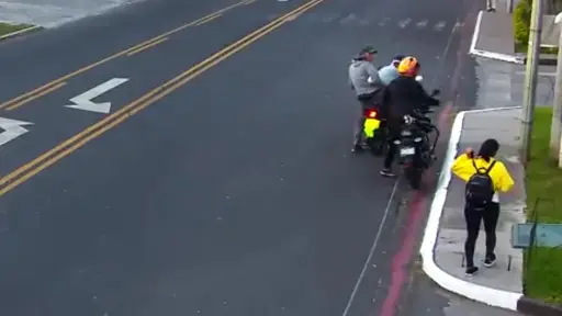 El motorista vestido de negro fue víctima de asalto por los otros dos hombres que están frente a él. ,Captura de pantalla. 
