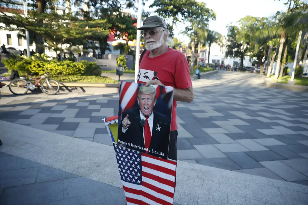 Un hombre sostiene una fotografía del presidente de Estados Unidos, Donald Trump, durante una manifestación en la plaza Simón Bolívar este sábado, en San Salvador (El Salvador),  EFE/ Rodrigo Sura
