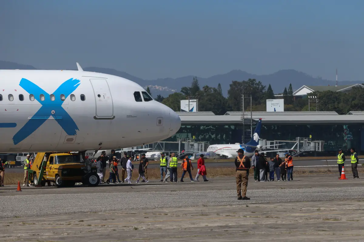 Personas caminan hacía el Centro de Recepción de Retornados al llegar en el tercer vuelo de ciudadanos retornados de Estados Unidos este martes, en la base de la Fuerza Aérea Guatemalteca., Foto EFE