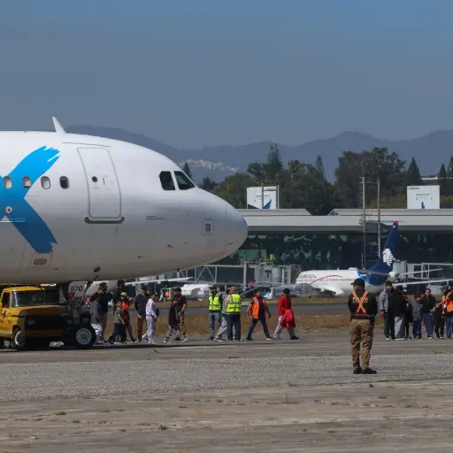 Personas caminan hacía el Centro de Recepción de Retornados al llegar en el tercer vuelo de ciudadanos retornados de Estados Unidos este martes, en la base de la Fuerza Aérea Guatemalteca. ,Foto EFE