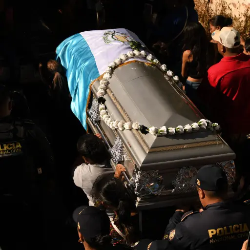 Integrantes de la PNC sostienen el féretro de su compañera Claudia Muñoz Ramos durante su sepelio este martes, en Jutiapa. ,EFE