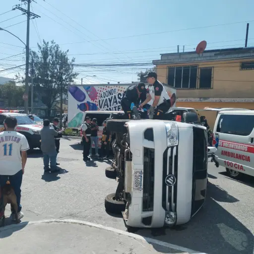 Paramédicos de Bomberos Volutarios atendieron al chofer de un vehículo de transporte, tras volcar en la zona 3. ,Bomberos Voluntarios.