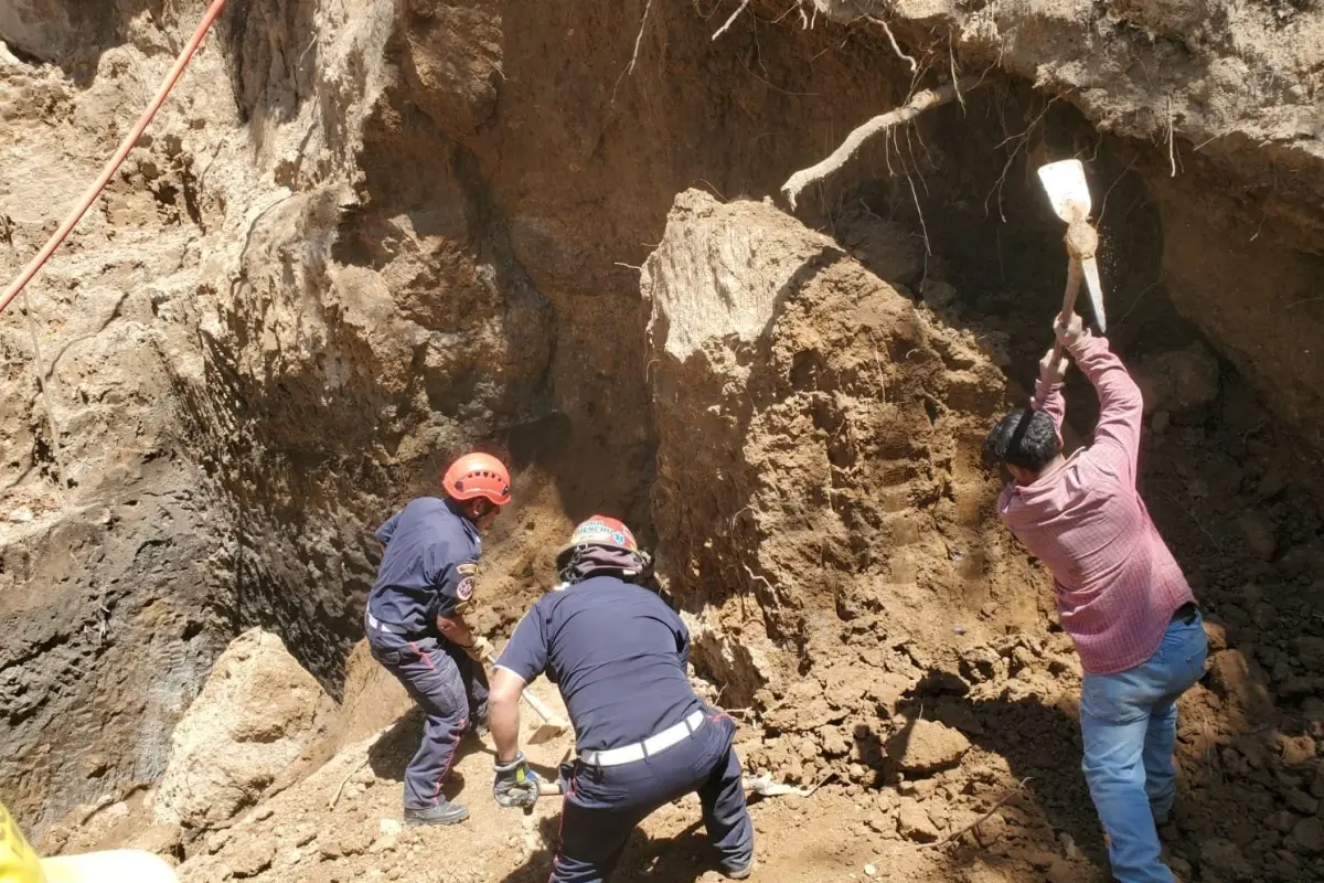 Varias personas apoyan en el proceso para recuperar al hombre soterrado., Bomberos Municipales Departamentales.