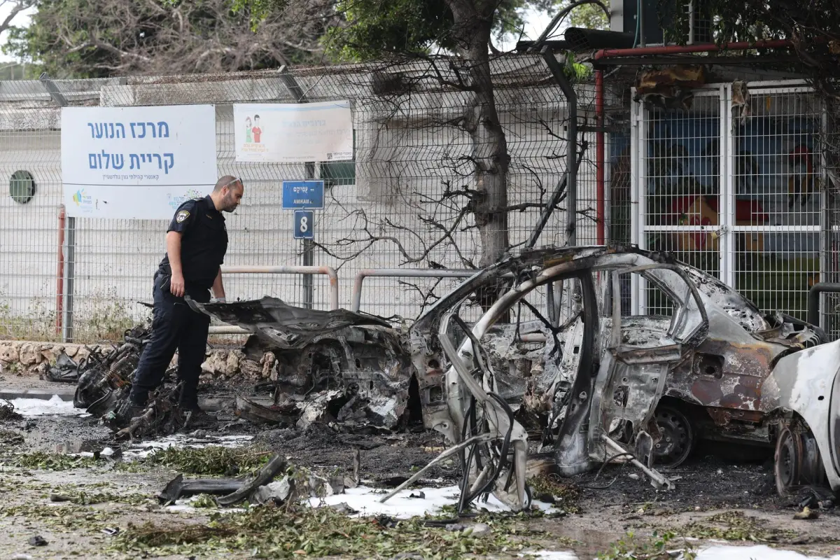 Un policía israelí inspecciona coches calcinados tras el impacto de fragmentos de un misil balístico iraní interceptado en Tel Aviv, Israel, el 15 de marzo de 2026, EFE/EPA/ABIR SULTAN